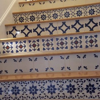 Staircase with patterned blue and white decorative tiles on the risers and wooden treads.