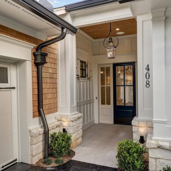 Modern house entrance with white siding, black door, house number 408, and exterior lantern light fixture.