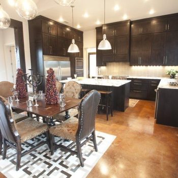 Modern kitchen and dining area with dark wood cabinets, island, stainless appliances, and a dining table set for six.